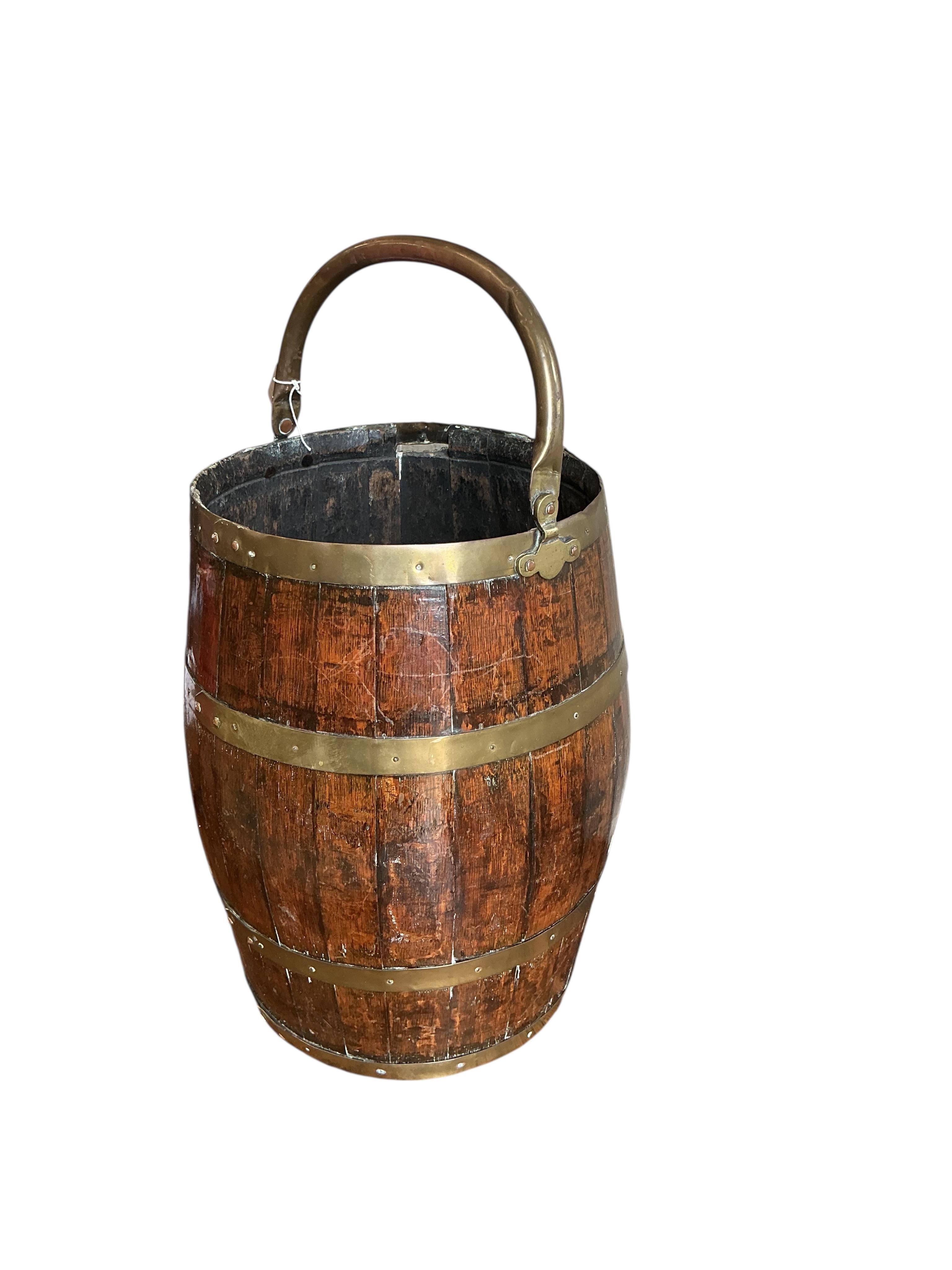 A brass bound coopered oak barrel with swing handle, height 48cm